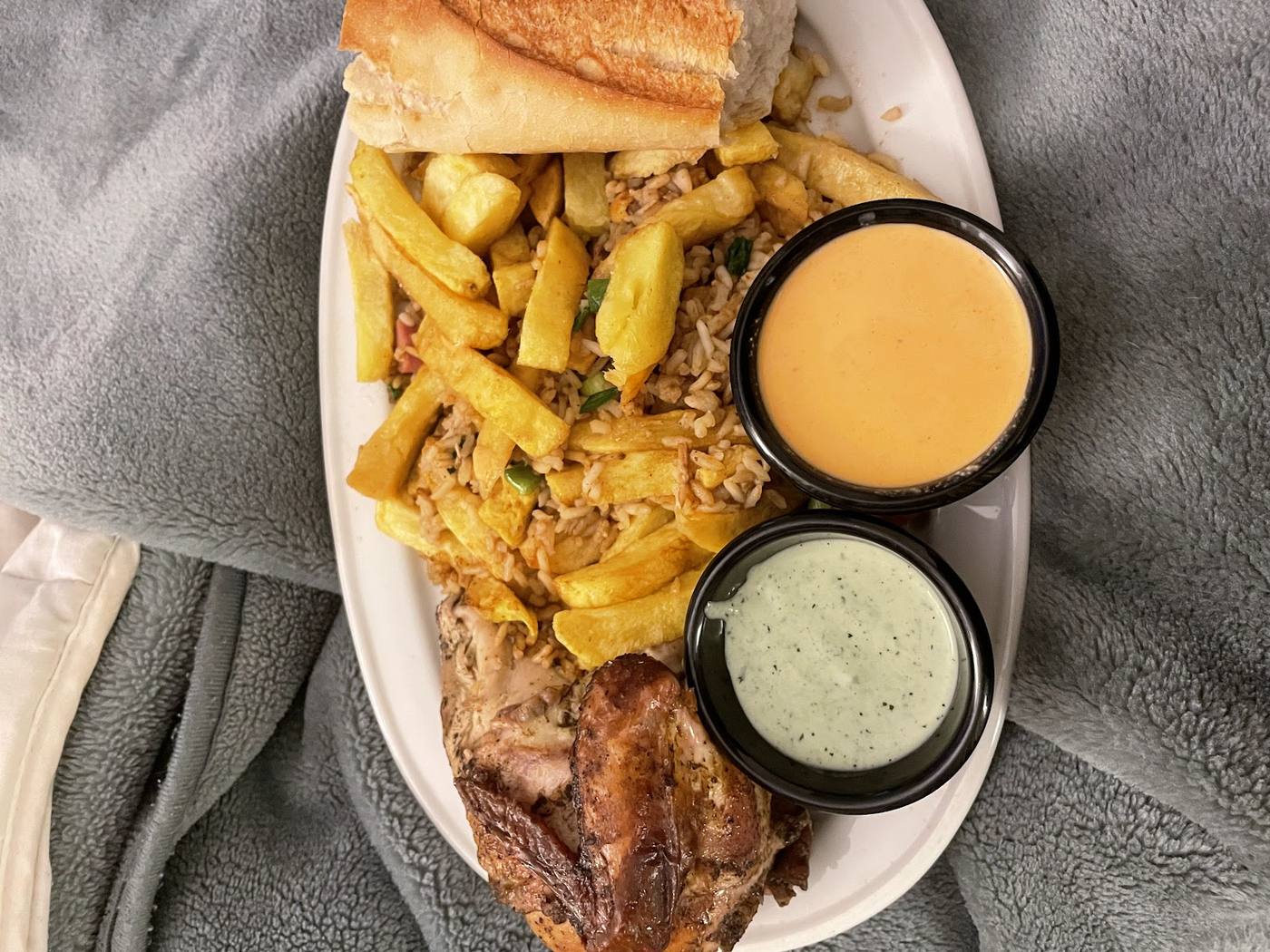 Medio pollo a la brasa acompañado de arroz chaufa, patatas fritas y salsas.
