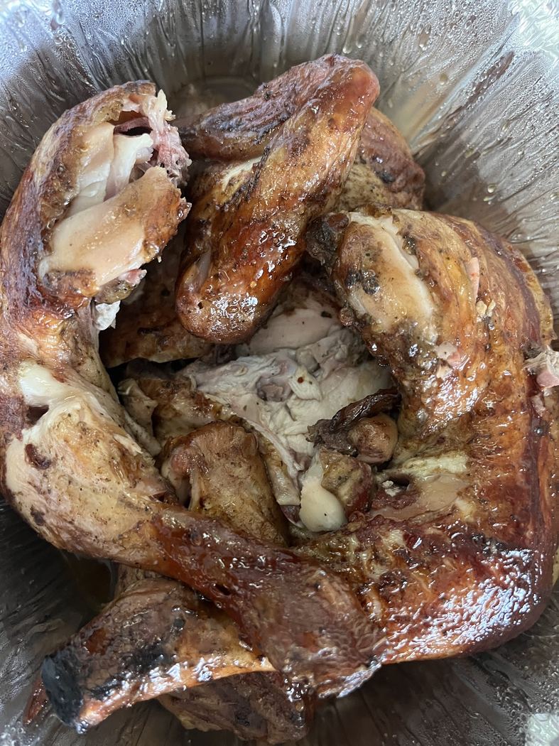 Pollo entero a la brasa, jugoso y con un ahumado perfecto.